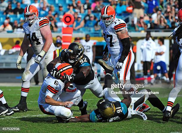 Brian Hoyer of the Cleveland Browns is sacked by Ziggy Hood and Chris Clemons of the Jacksonville Jaguars at EverBank Field on October 19, 2014 in...