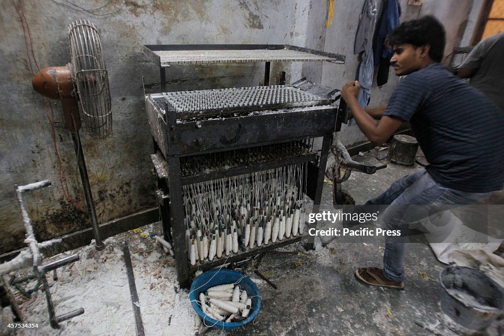 A worker makes candles ahead of Diwali festival in side a...