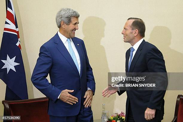 Secretary of State John Kerry and Prime Minister of Australia Tony Abbot prepare to shake hands at the beginning of a meeting in Jakarta on October...