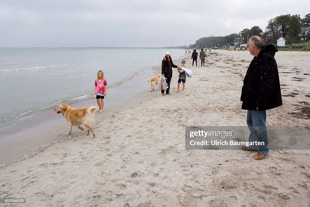 Walkers And Dogs On The Beach Of Scharbeutz.