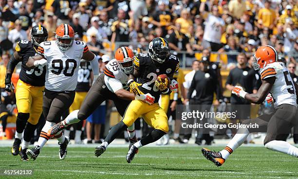 Running back Le'Veon Bell of the Pittsburgh Steelers is tackled by defensive lineman Armonty Bryant of the Cleveland Browns as defensive lineman...