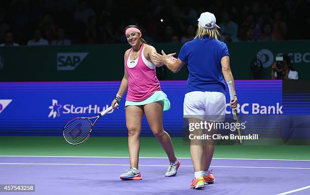 Martina Navratilova of the United States and Marion Bartoli of France celebrate a point on their way to victory against Tracy Austin of the United...