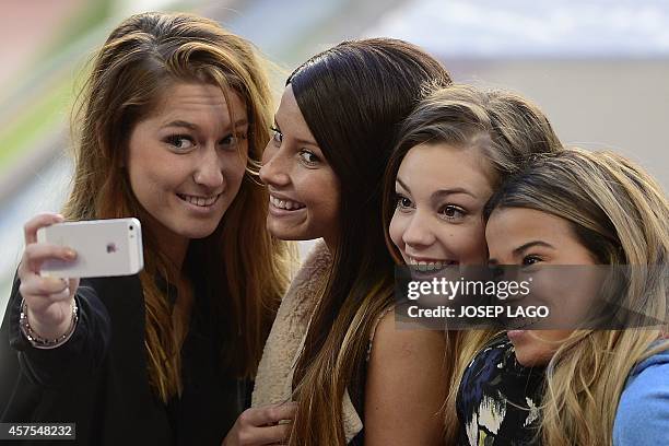 Girlfriends of Ajax's football players take a selfie during a training session at the Camp Nou stadium in Barcelona on October 20, 2014 on the eve of...