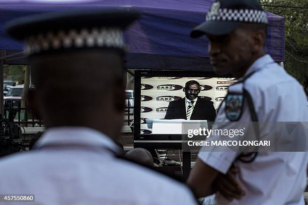 Botswana policeman looks on while with a colleague watch the Botswana Congress Party president Dumelang Saleshando addressing the first of two...