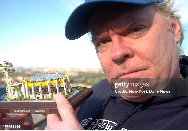 David Oats, Pres. Of the Flushing Meadow-Corona Park World's Fair Association with model calls for a repair light atop of the New York State Pavillon...