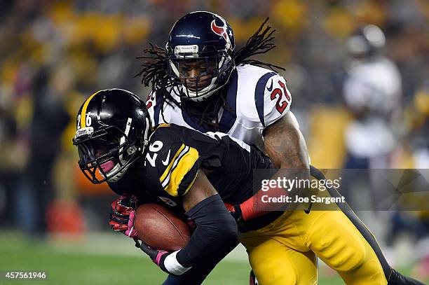 Le'Veon Bell of the Pittsburgh Steelers runs the ball against Kendrick Lewis of the Houston Texans in the first quarter during their game at Heinz...