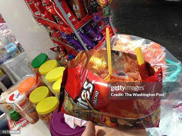 Bag of "Crazy Doritos" topped with shredded carrot, jimaca, cucumber, peanuts, pork rinds, candy, spices and hot sauce costs about $1.50 on the...