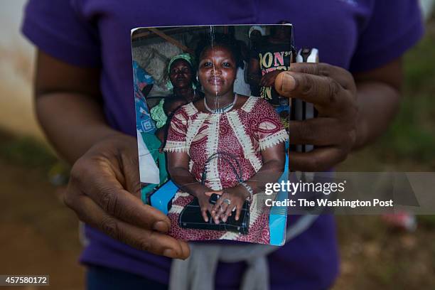 October 16: Prince Nyumahs sister holds a photo of their younger sister outside the Island Clinic Ebola treatment center, where they have been...