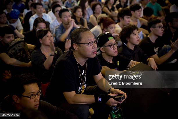 Benny Tai Yiu-ting, co-founder of activist group Occupy Central with Love and Peace , center, watches a live televised talk between pro-democracy...
