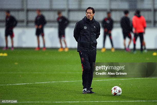 Head coach Roger Schmidt walks past the players during a Bayer Leverkusen training session ahead of their UEFA Champions League Group C match against...