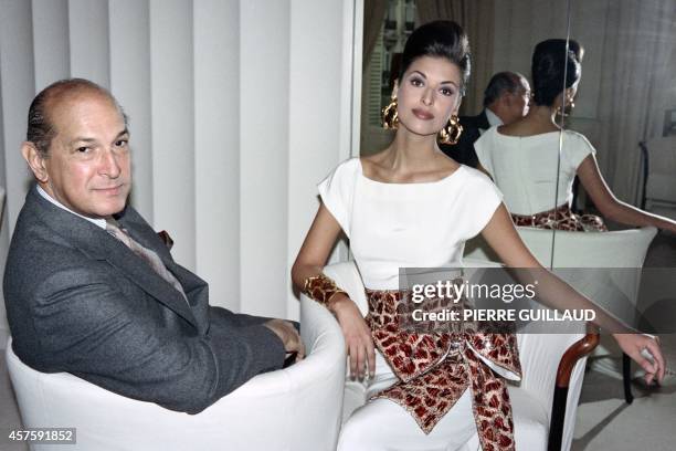 This file picture taken on January 19, 1993 in Paris shows designer Oscar de la Renta, then Pierre Balmain's new stylist, posing with a model...