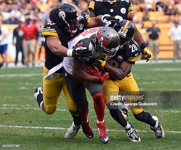 Wide receiver Louis Murphy of the Tampa Bay Buccaneers is tackled by safety Troy Polamalu and cornerback Cortez Allen of the Pittsburgh Steelers...