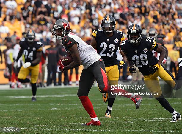 Wide receiver Louis Murphy of the Tampa Bay Buccaneers runs with the football after catching a pass as he is pursued by cornerback Cortez Allen and...