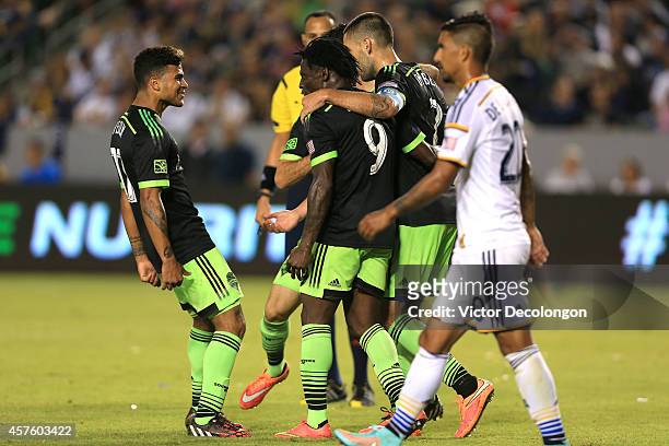 DeAndre Yedlin , and Clint Dempsey of Seattle Sounders FC congratulate jubilant teammate Obafemi Martins after Martins scored a goal to tie the match...