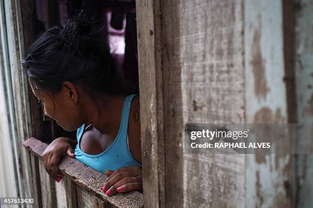 Woman looks through a window in the Comunidade Negra do Barranco Sao Banadito village in Manaus, Brazil on October 20th, 2014. The Comunidade Negra...