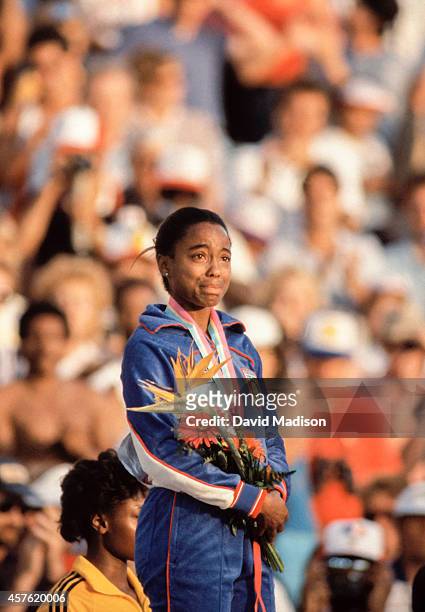 Evelyn Ashford of the USA listens to the national anthem during the awards ceremony for the Women's 100 meter event of the track and field...