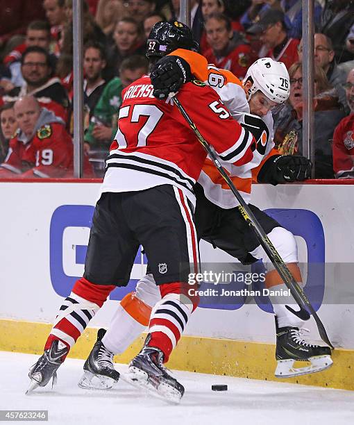 Trevor van Riemsdyk of the Chicago Blackhawks pins Chris Vande Velde of the Philadelphia Flyers at boards as they battle for the puck at the United...