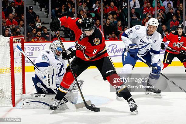 Joe Colborne of the Calgary Flames tries to re-direct a puck past goalie Evgeni Nabokov of the Tampa Bay Lightning at Scotiabank Saddledome on...