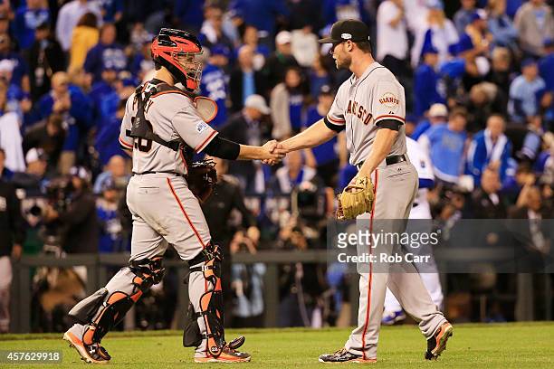Hunter Strickland of the San Francisco Giants celebrates with Buster Posey after defeating the Kansas City Royals by a score of 7-1 to win Game One...