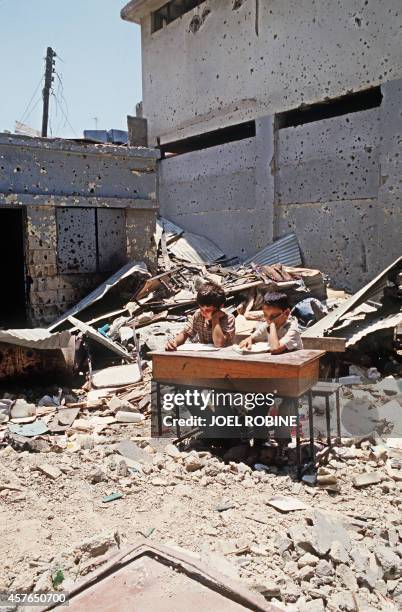 Two Palestinian children study in the courtyard of the school of the refugee camp in Shatila, near Beirut, 23 June 1985. Deux enfants palestiniens...