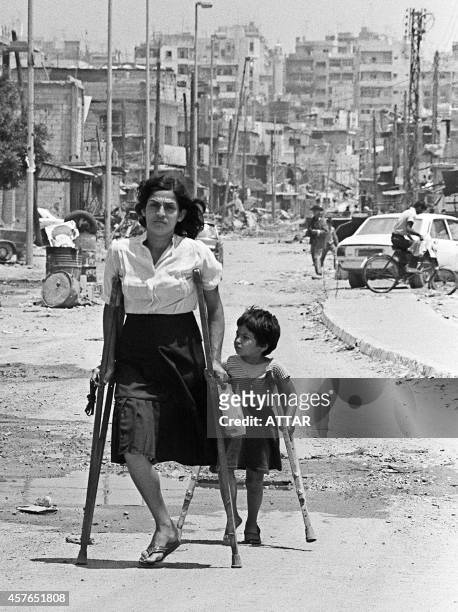 Palestinian woman and her daughter come back from the Shatila refugee camp, near Beirut, 10 June 1985, where they went to see what was left from...