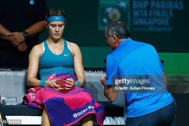 Eugenie Bouchard of Canada receives coaching from Nick Saviano in her match against Ana Ivanovic of Serbia during day three of the BNP Paribas WTA...