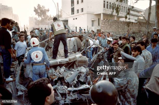 Civil defense rescuers inspect the debris of a car in which President Rene Moawad's bodyguards were killed, on November 22 after a powerful explosion...