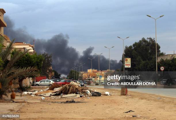 Picture taken on October 22, 2014 in the Libya's eastern coastal city of Benghazi shows smoke billowing from buildings after Libyan airforce, loyal...