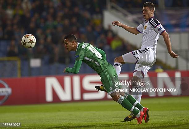 Ludogorets Razgrad's midfielder from Brazil Marcelinho heads the ball in front of Basel's defender Fabian Schar during the UEFA Champions League...