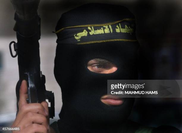 An Islamic Jihad militant poses with his weapon during the funeral of killed Palestinians Amin al-Dahduh of Islamic Jihad and his 20-year-old cousin...