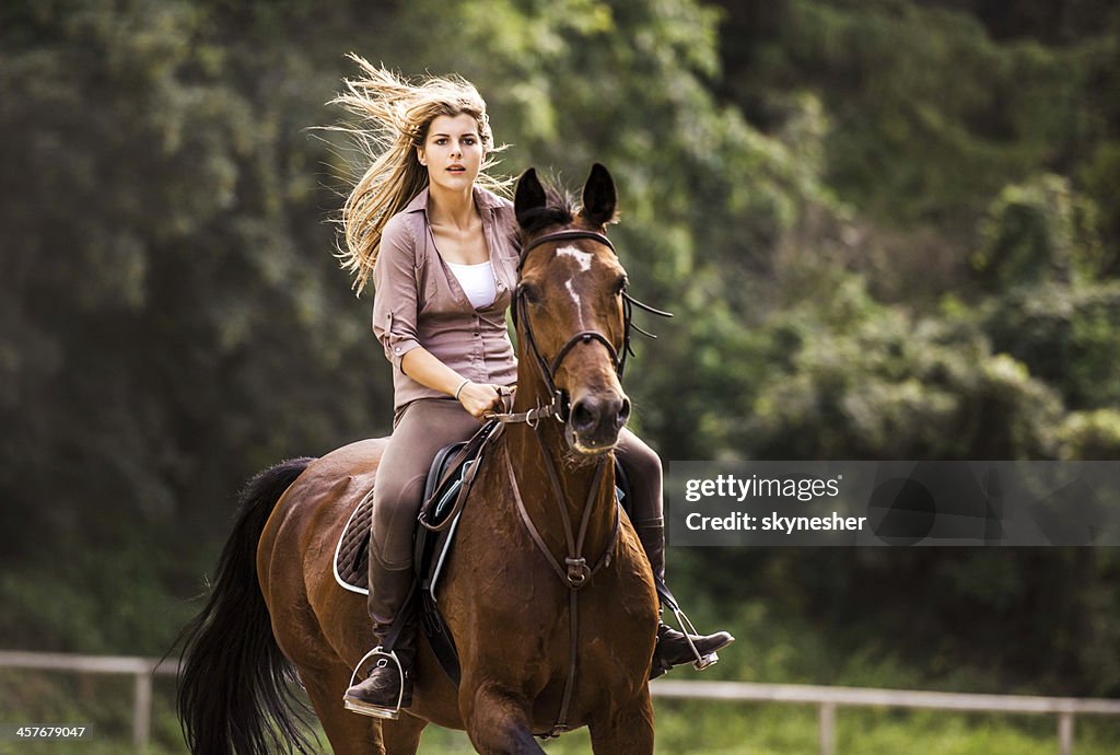 Woman horseback riding.
