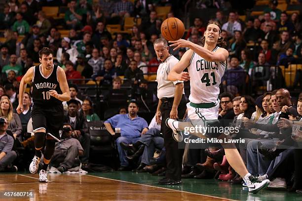 Kelly Olynyk of the Boston Celtics jumps to save the ball from going out of bounds against the Brooklyn Nets during a preseason game at TD Garden on...