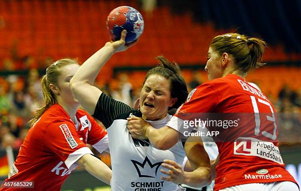 Germany's Anna Loerper vies with Denmark's Anne Mette Hansen and Marianne Bonde Pedersen during the Women's Handball World Championship 2013 quarter...