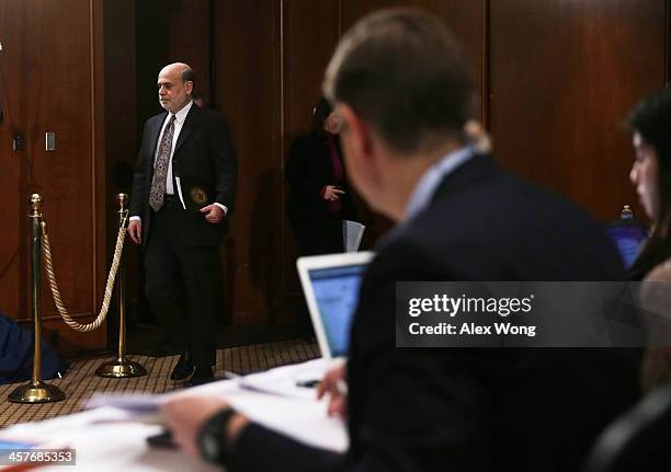 Federal Reserve Board Chairman Ben Bernanke arrives at a news conference after a Federal Open Market Committee meeting December 18, 2013 at the...