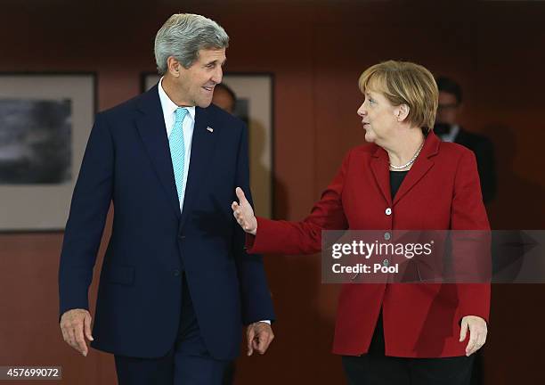 Secretary of State John Kerry and German Chancellor Angela Merkel arrive to give statements to the media prior to talks at the Chancellery on October...