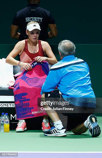 Caroline Wozniacki of Denmark receives advice from father and coach Piotr Wozniacki in her match against Agnieszka Radwanska of Poland during day...