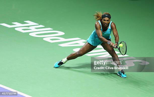 Serena Williams of the United States stretches to play a backhand against Eugenie Bouchard of Canada in their round robin matchduring the BNP Paribas...