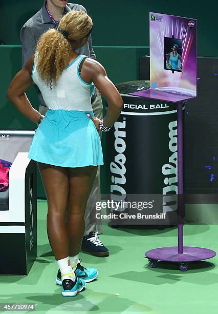 Serena Williams of the United States takes a photograph for twitter social media site after her straight sets victory against Eugenie Bouchard of...