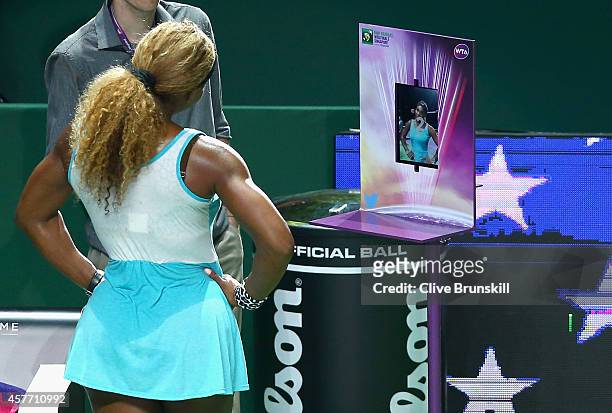 Serena Williams of the United States takes a photograph for twitter social media site after her straight sets victory against Eugenie Bouchard of...