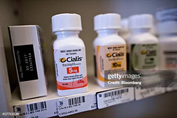 Bottles of Eli Lilly & Co. Cialis brand medication sits on a pharmacy shelf in Princeton, Illinois, U.S., on Wednesday, Oct. 22, 2014. Eli Lilly is...