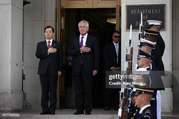 Secretary of Defense Chuck Hagel and National Defense Minister of Korea Han Min Koo listen to national anthems during a honor cordon at the Pentagon...