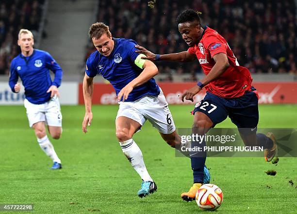 Lille's Belgian forward Divock Origi vies for the ball with Everton's British defender Philip Jagielka next to Everton's defender Tony Hibbert during...