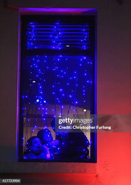 Children look out of a restaurant window look to watch fireworks as people celebrate the Hindu festival of Diwali on October 23, 2014 in Leicester,...