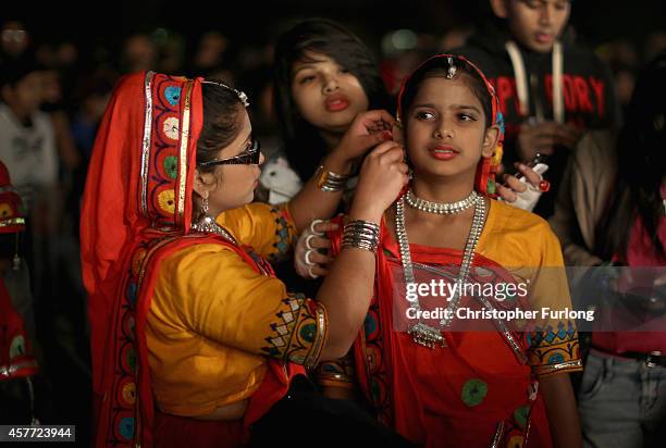 Young dancers prepare their costumes as they wait their turn to entertain people celebrating the Hindu festival of Diwali on October 23, 2014 in...