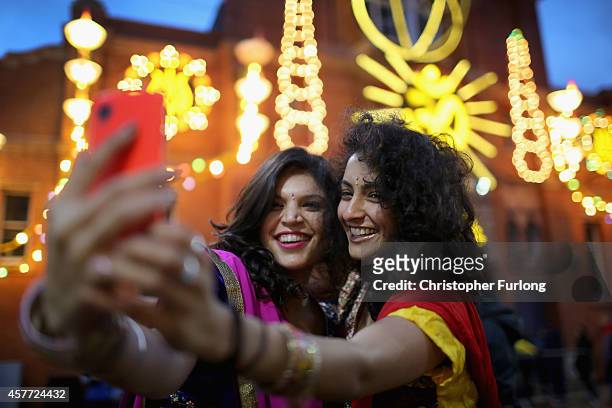 Friends Aanka Batta and Kelly Vaduka take a selfi in front of illuminations as they celebrate the Hindu festival of Diwali on October 23, 2014 in...