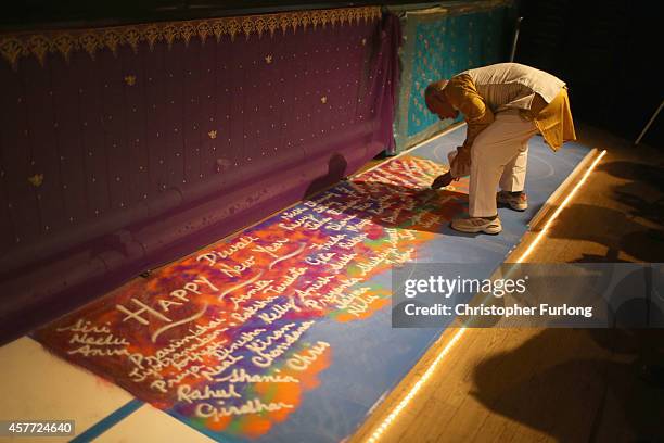Rangoli artist creates a sand picture with the names of people attending the Hindu festival of Diwali on October 23, 2014 in Leicester, England. Up...