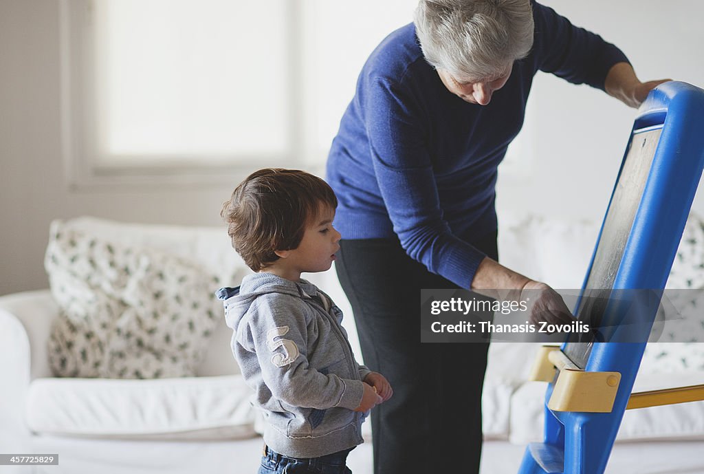 Grandmother teaching how to write to her grandson