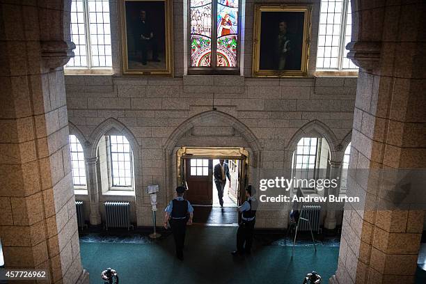 Constables guard the House of Commons side of the Canadian Parliament one day after a gunman infiltrated the building before being shot dead, on...