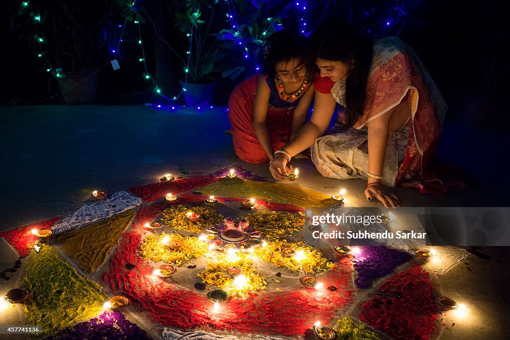 A woman and daughter lit earthen lamps on Diwali. Diwali...