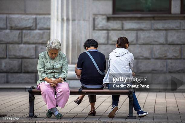 An old woman sits on the street napping. In China, there are more than 200 million old people of over 60 years old at present, which accounts for 15%...
